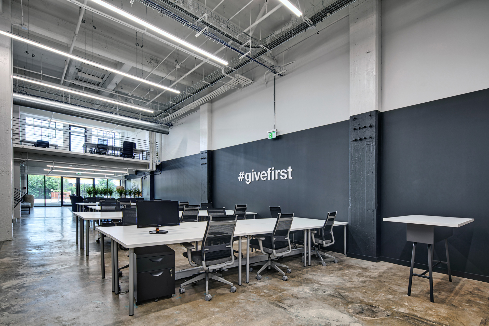 Large office space with desktop computer and seating areas at The Denham Building apartments for rent in South Birmingham, AL